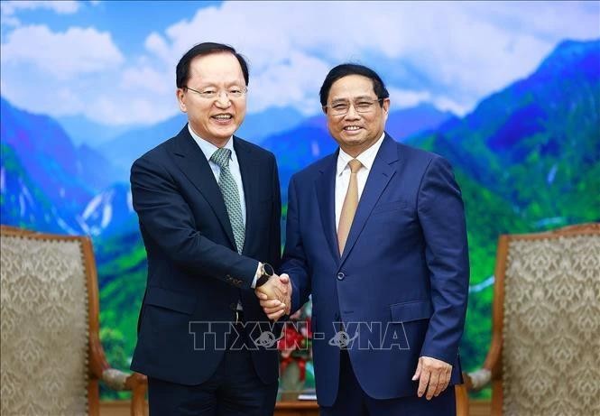 Le Premier ministre Pham Minh Chinh (à droite) serre la main du directeur financier de Samsung Electronics Park Hark-kyu, à Hanoi, le 9 mai. Photo : VNA.