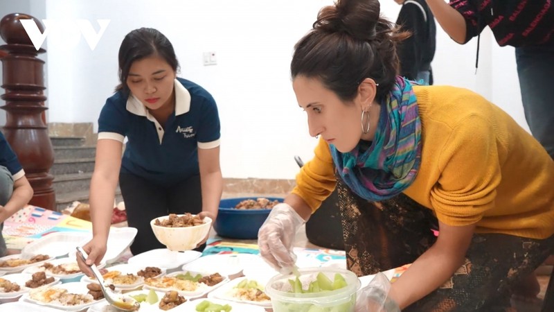 Une touriste étrangère à Sa Pa participe à la préparation de repas de charité à envoyer aux zones inondées. Photo : VOV.