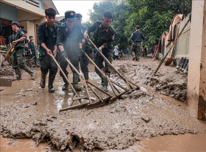 Des policiers aides des habitants de la commune de Phuc Khanh, district de Bao Yen, province de Lao Cai, à nettoyer leurs maisons après le typhon Yagi. Photo : VNA.