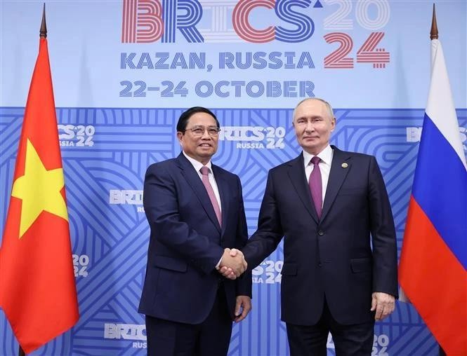 Le Premier ministre Pham Minh Chinh (à gauche) et le président russe Vladimir Poutine se serrent la main, à Kazan, en Russie. Photo : VNA.