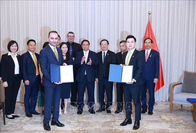 Le Premier ministre Pham Minh Chinh (centre) assiste à la remise du protocole d'accord sur la recherche d'investissement dans le projet de complexe sportif et de centre commercial à Dong Anh entre T&T du Vietnam et JTA International Holding. Photo : VNA. 