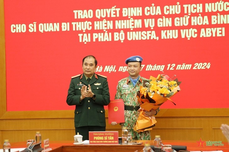 Le général de corps d’armée Phung Si Tân (à gauche) remet la décision d'affectation au lieutenant-colonel Hoàng Dinh Công. Photo : qdnd.vn