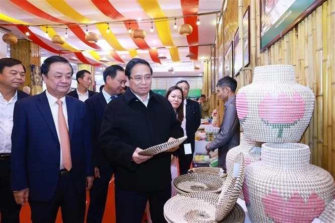 Le Premier ministre Pham Minh Chinh (à droite, au premier plan) visitant un stand d’exposition des produits artisanaux, à Hanoi, le 27 décembre. Photo : VNA.