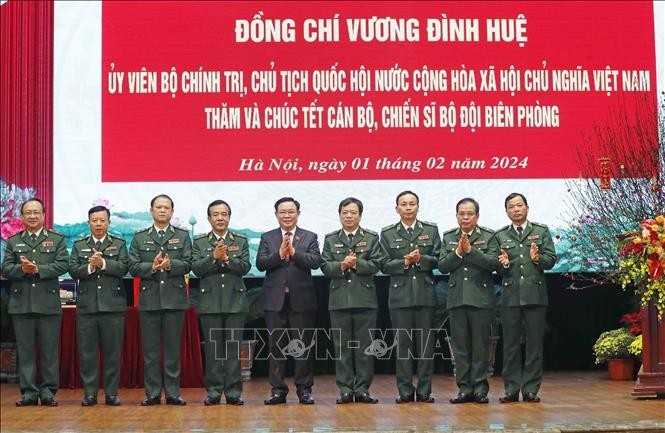 Le Président de l’AN Vuong Dinh Huê (au milieu) prend photo avec des gardes-frontières. Photo : VNA.