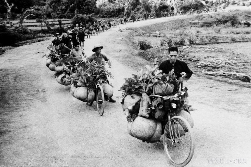 Un groupe de personnes avec des charrettes servant les lignes de front. Photo : VNA.