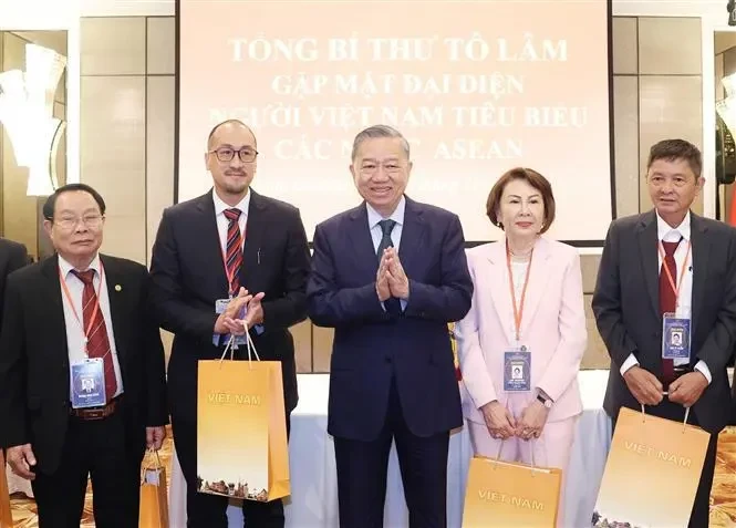 Le secrétaire général du Comité central du Parti communiste du Vietnam, To Lam (au centre), offre des cadeaux à des Vietnamiens exceptionnels vivant dans les pays de l'ASEAN. Photo : VNA.