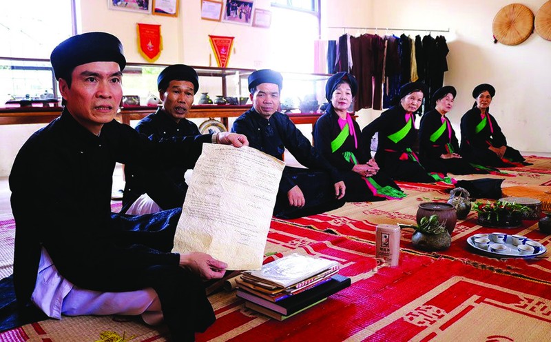 Duong Duc Thang (1er à gauche) présente un document sur les airs authentiques de "quan ho". Photo : BBN/CVN.