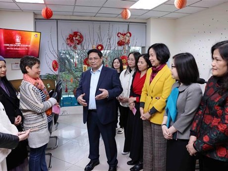 Le PM Pham Minh Chinh encourage et adresse ses vœux de Nouvel An aux journalistes du Département des informations internationales de l’Agence vietnamienne d’information (VNA). Photo : VNA.