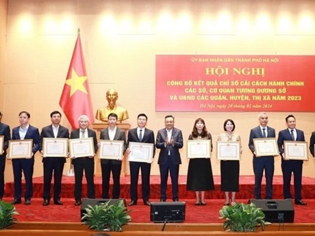 Le président du Comité populaire de Hanoï, Tran Sy Thanh (6e, à droite), remet des satisfecits aux collectivités excellentes en matière de réforme administrative en 2023. Photo: NDEL.