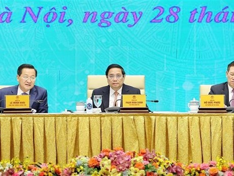 Le Premier ministre Pham Minh Chinh (au milieu) préside conférence visant à déployer les tâches de la Bourse vietnamienne de 2024. Photo : VNA.