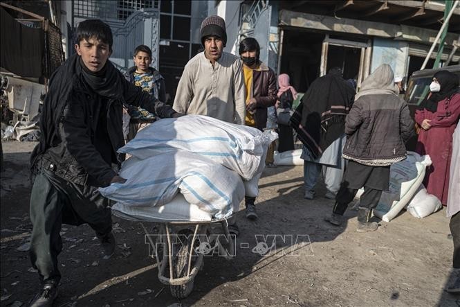 Des Afghans attendant des aides humanitaires à Kaboul. Photo : VNA.