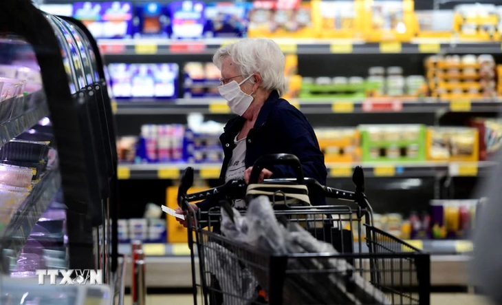 Une femme fait ses courses dans un supermarché en Allemagne. Photo : VNA.