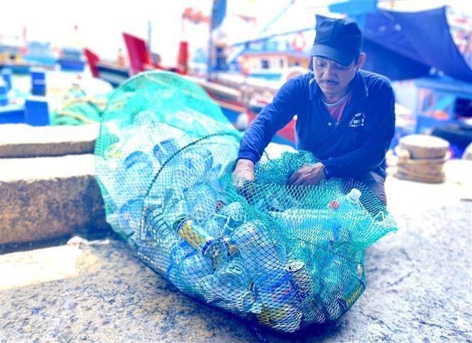 Des pêcheurs de Binh Dinh ramènent à terre leurs déchets plastiques. Photo : VNA.