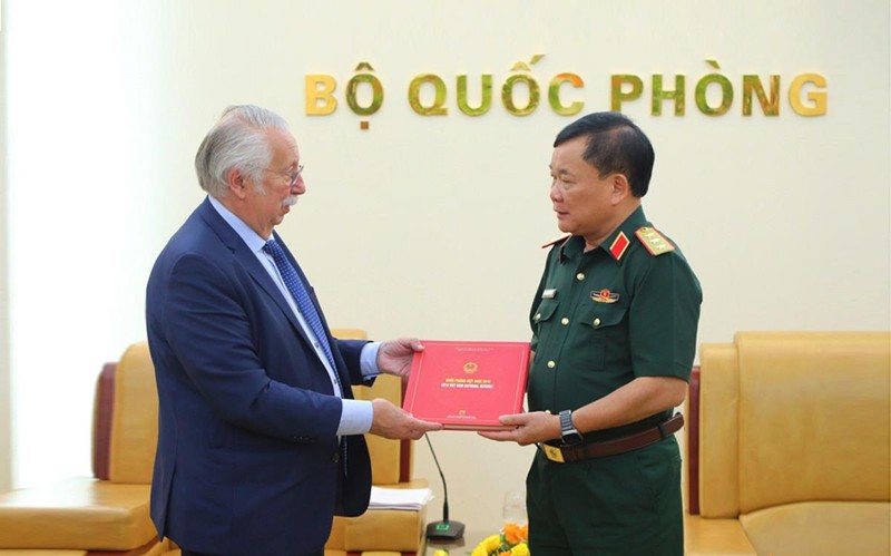 Le général de corps d’armée Hoang Xuan Chien, vice-ministre vietnamien de la Défense (à droite), remet à André Flahaut, ministre d’État et ancien président de la Chambre des représentants de Belgique, le Livre blanc sur la défense du Vietnam 2019, le 20 mai à Hanoï. Photo: bienphong.com.vn.