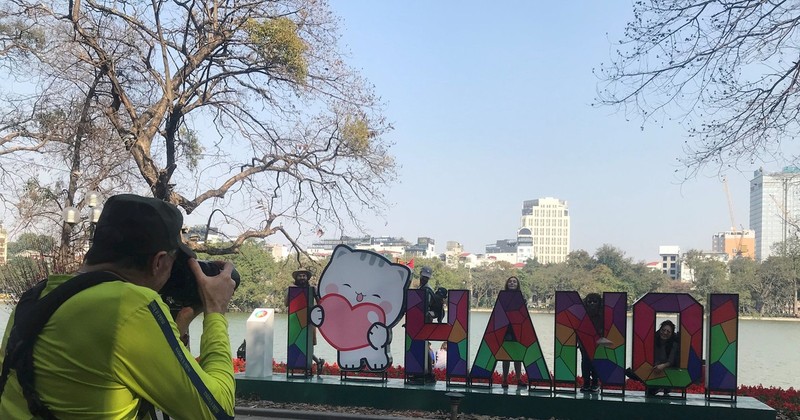 Des touristes au lac de Hoan Kiem (Epée restituée). Photo : daidoanket.