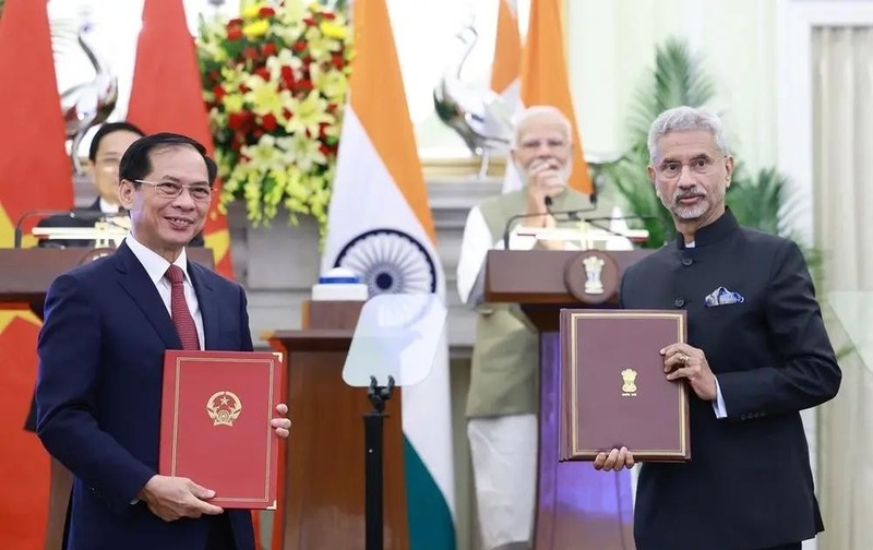 Les responsables des ministères des Affaires étrangères du Vietnam et de l’Inde s’échangent l'accord entre les deux gouvernements permettant aux proches des membres des missions diplomatiques et des consulats de travailler contre rémunération. Photo : VNA