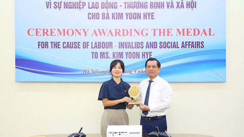 Le vice-ministre vietnamien du Travail, des Invalides de guerre et des Affaires sociales, Nguyen Ba Hoan (à droite), remet l’insigne « Pour l'œuvre du travail, des invalides de guerre et des affaires sociales » à Kim Yoon Hye, attaché au travail et à l'emploi de l'ambassade de la République de Corée au Vietnam, le le 18 septembre à Hanoi. Photo : molisa.gov.vn.