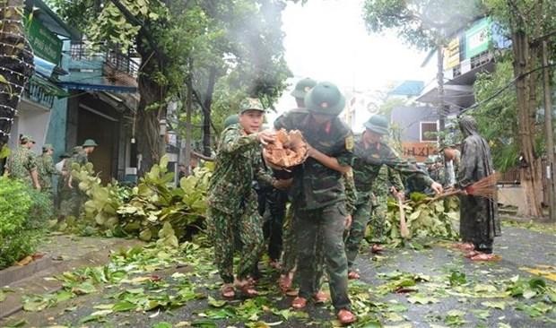 Des miliaires aident à déplacer des arbres abattus. Photo : VNA.