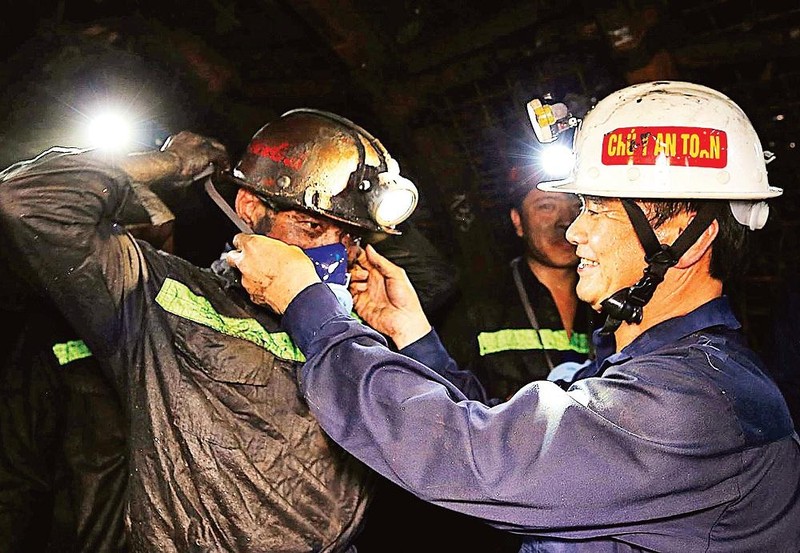 Le président du syndicat du Groupe national des industries du charbon et des minéraux du Vietnam, Lê Thanh Xuân, remet des masques aux ouvriers de la compagnie de charbon Nam Mâu. Photo : Quôc Khang.