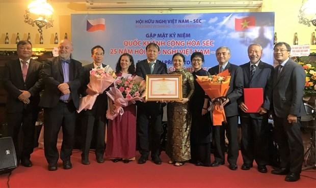L'ambassadrice Nguyên Phuong Nga, présidente de l'Union des organisations d'amitié du Vietnam (5e à partir de la droite), remet un satisfecit du Premier ministre à l'Association d'amitié Vietnam - République tchèque. Photo : VNA.