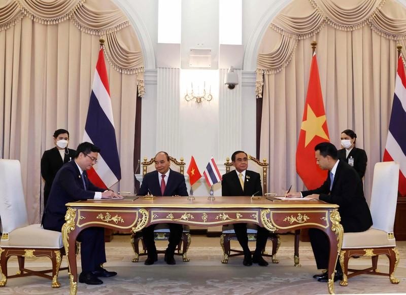 Les représentants de Vietcombank et d'Eximbank signent l'accord de coopération en présence du Président vietnamien, Nguyên Xuân Phuc, et du Premier ministre thaïlandais, Prayuth Chan-ocha. Photo : VNA.