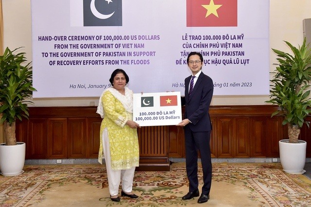 Le vice-ministre des Affaires étrangères, Dô Hùng Viêt, remet un montant symbolique de 100 000 dollars à l’ambassadrice du Pakistan, Samina Mehtab. Photo : VGP.