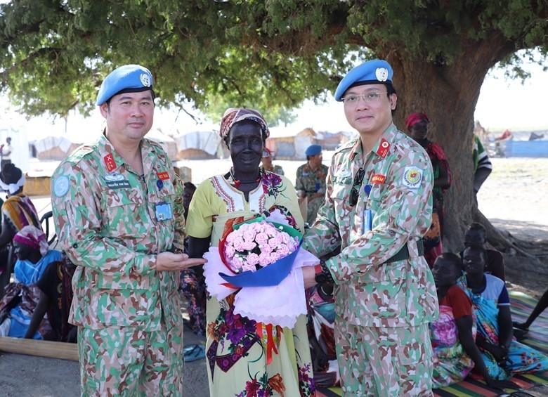 Des représentants de l’hôpital de campagne de niveau, 2 N° 4 offrent des fleurs à une Sud-Soudanaise à l’occasion de la Journée internationale des femmes. Photo : VNA. 