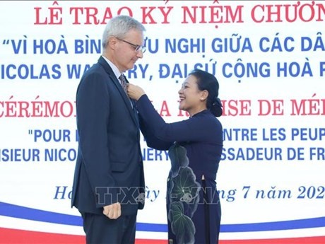 L'ambassadrice Nguyên Phuong Nga, présidente de l'Union des Organisations d'Amitié du Vietnam (VUFO), remet l’insigne "Pour la paix et l'amitié entre les nations" à l'ambassadeur de France au Vietnam, Nicolas Warnery. Photo : VNA.