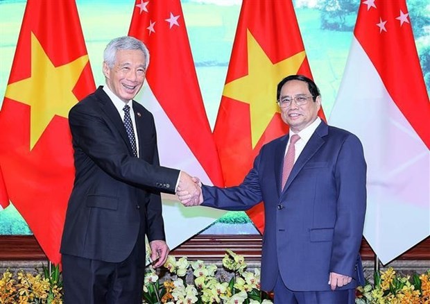 Le Premier ministre vietnamien, Pham Minh Chinh (à droite) et homologue singapourien, Lee Hsien Loong, se serrent la main, à Hanoi, le 28 août. Photo : VNA. 