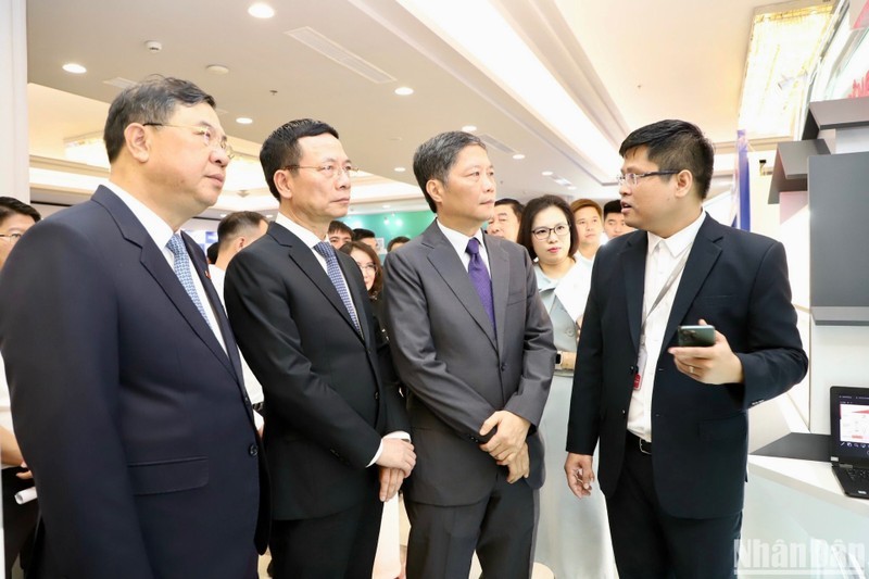 Les dirigeants de la Commission économique du Comité central du Parti, du Ministère de l’Information et des Communications et de la province de Nam Dinh visitent une exposition dans le cadre du forum. 