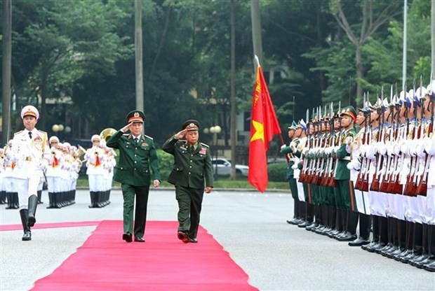 Le chef du Département général de la politique de l’Armée populaire du Vietnam, Luong Cuong, et son homologue lao Thongloi Silivong passent en revue une garde d’honneur. Photo : VNA