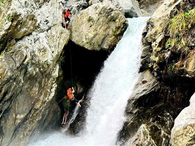 Les secouristes sont descendus en rappel de la cascade pour sauver le tourite bloqué. Photo : VNA.