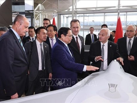  Le Premier ministre Pham Minh Chinh contemple le modèle d'un produit de la la société Turkish Aerospace Industries. Photo : VNA.
