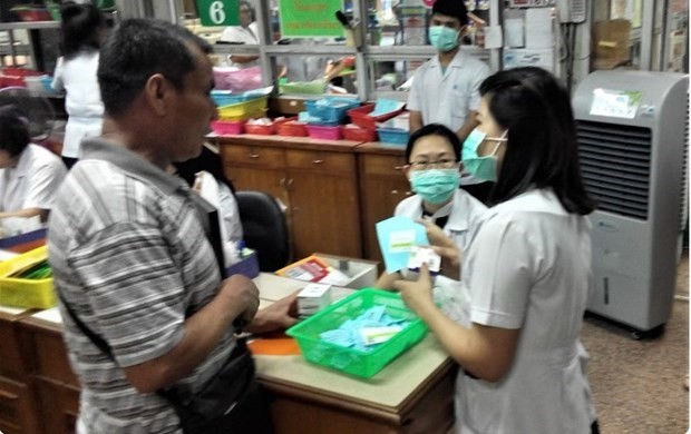 Le personnel de l'hôpital Samut Sakhon explique les médicaments à prendre à un travailleur migrant qui subit un examen médical dans le cadre du processus d'enregistrement du travail dans la province adjacente à Bangkok. Photo : bangkokpost.com