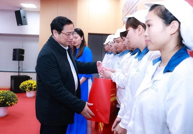 Le Premier ministre Pham Minh Chinh (à gauche) offre des cadeaux à des ouvriers en difficulté. Photo : VNA.