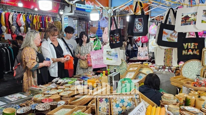 Les touristes étrangers aiment acheter des souvenirs vietnamiens au marché nocturne du vieux quartier de Hanoï. 