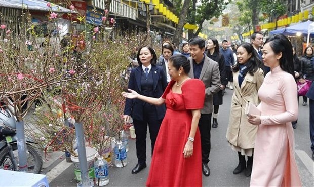 L'épouse du Président Vo Van Thuong, Phan Thi Thanh Tâm, et Mme Louise Araneta Marcos, épouse du Président philippin Ferdinand Romualdez Marcos Jr, visitent le marché aux fleurs de Hàng Luoc. Photo : VNA.