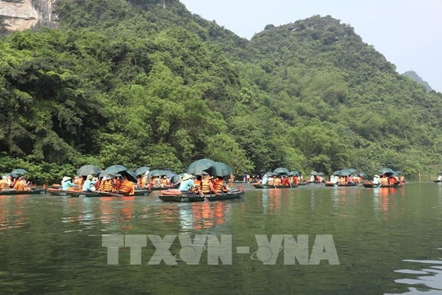 Des touristes au complexe paysager de Trang An, dans la province de Ninh Binh, - premier patrimoine mixte culturel et naturel du Vietnam à être inscrit dans la Liste du patrimoine mondial de l’UNESCO. Photo: VNA.