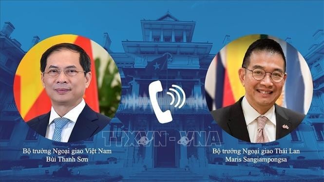 Les deux ministres des AE du Vietnam (gauche) et de la Thaïlande s’entretiennent au téléphone. Photo : VNA.