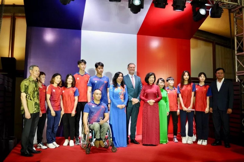 La vice-ministre vietnamienne Lê Thị Thu Hang, l’ambassadeur Olivier Brochet et les participants posent avec les athlètes vietnamiens se préparant à participer aux Jeux olympiques et paralympiques de Paris 2024. Photo : baoquocte. 