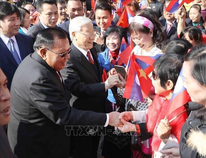 Le secrétaire général du Parti Nguyên Phu Trong et le secrétaire général du Parti et président du Laos Bounnhang Vorachith rencontrent des habitants , à Hanoi, le 22 juillet 2024. Photo : VNA.