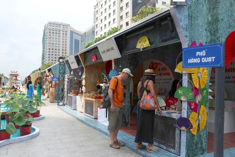 Les touristes étrangers visitent un stand des produits de Hanoï. Photo : Quang Châu/CVN.