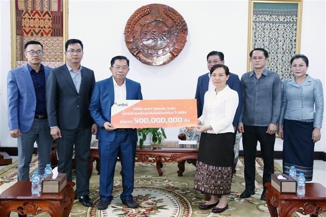 Un représentant d'une entreprise vietnamienne au Laos remet un don aux localités lao touchées par les inondations. Photo : VNA.