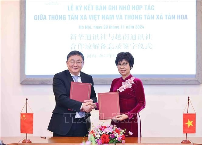 La directrice générale de la VNA Vu Viêt Trang et le rédacteur en chef adjoint de Xinhua Ren Weidong signent un protocole d'accord sur les plans de coopération en 2025. Photo : VNA.