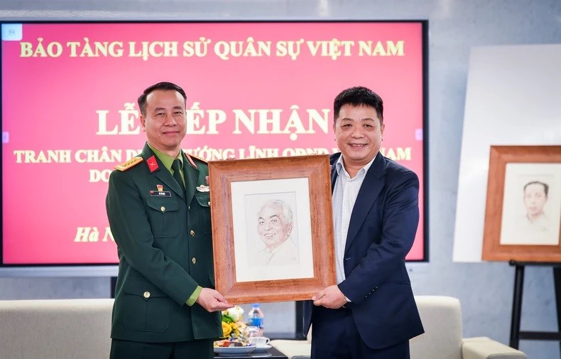 Quê Dinh Nguyên (à droite), rédacteur en chef adjoint du journal Nhân Dân, a remis la collection de portraits des généraux talentueux au Musée d’histoire militaire du Vietnam. 