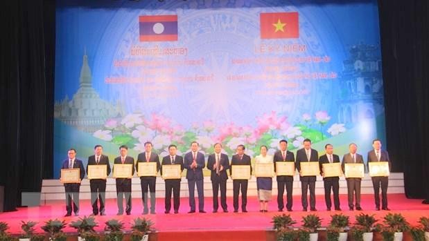 Remise des satisfécits aux collectifs et individus laotiens pour leurs contributions au renforcement des relations spéciales entre le Vietnam et le Laos. Photo : VNA