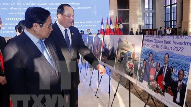 Le Premier ministre Pham Minh Chinh (à gauche) et son homologue lao, Sonexay Siphandone, ont visité jeudi matin une exposition de photos sur les réalisations de la coopération entre le Vietnam et le Laos à Vientiane. Photo : VNA.