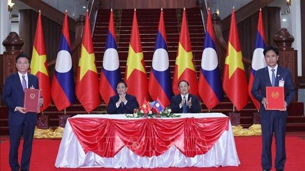 Les Premiers ministres vietnamien Pham Minh Chinh (assis, à gauche) et lao Sonexay Siphandone supervisant la signature de l’accord d’entraide judiciaire en matière civile. Photo : VNA
