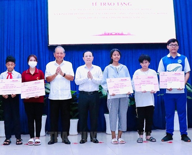 L'ancien vice-Premier ministre permanent Truong Hoa Binh (2e, gauche) remet des bourses d'études aux élèves défavorisés de l'ethnie khmère à Ho Chi Minh-Ville. Photo: VNA