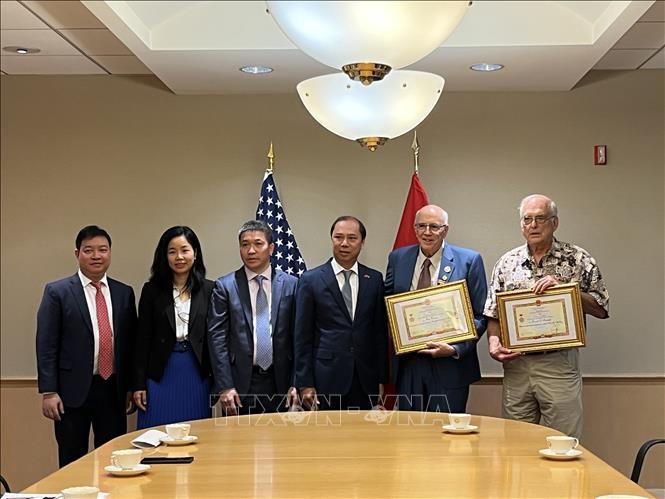 Lors de la cérémonie de remise de l’insigne « Pour la paix et l’amitié entre les peuples » à trois américains. Photo: VNA